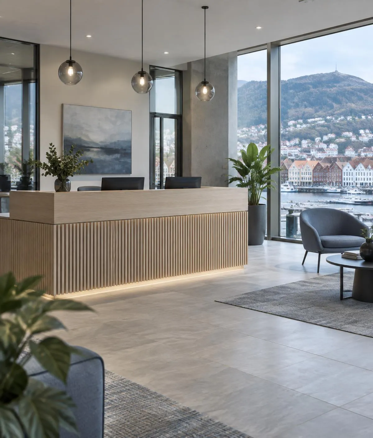Resepsjon med trebekledd skranke og store vinduer med utsikt over Bryggen i Bergen